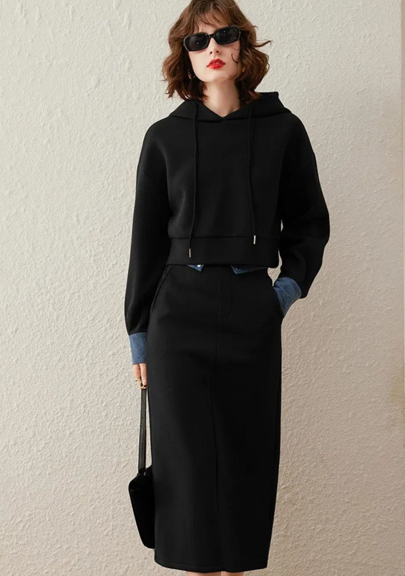 Bakfra bilde av svart hettegenser og skjørt med splitt